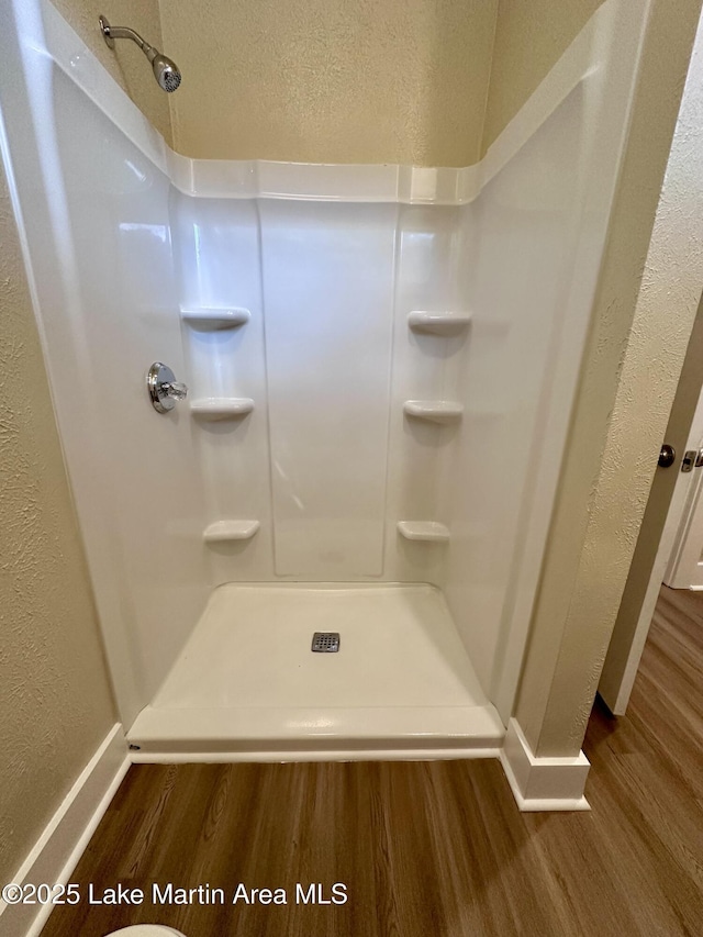 104 Central Blvd, East Tallassee, AL 36078 - bathroom featuring wood finished floors, a shower stall, and a textured wall