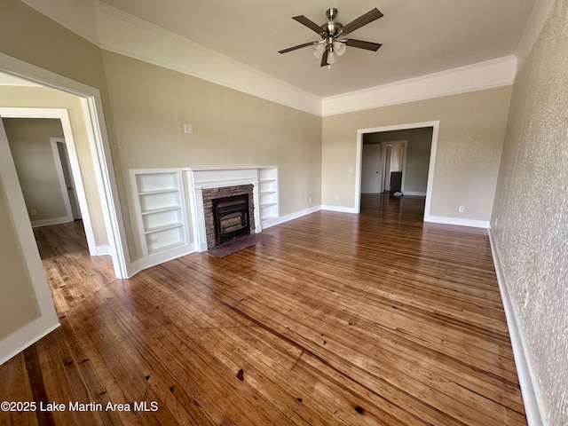 104 Central Blvd, East Tallassee, AL 36078 - unfurnished living room with ornamental molding, built in features, a ceiling fan, hardwood / wood-style floors, and a fireplace
