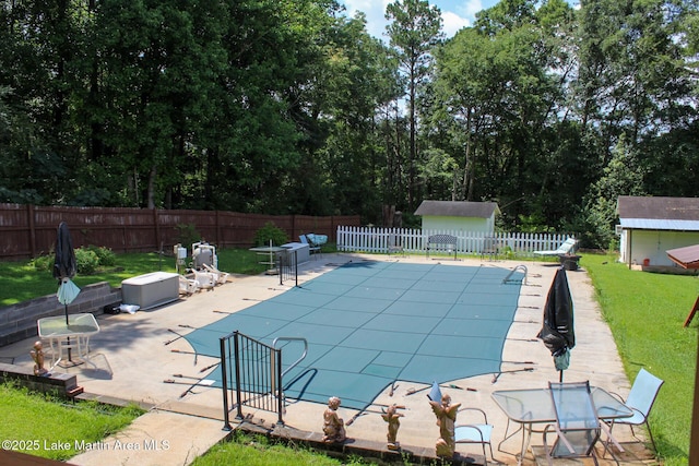 295 Landers Loop, Sylacauga, AL 35150 - view of swimming pool with a fenced backyard, a shed, a patio, and view of wooded area