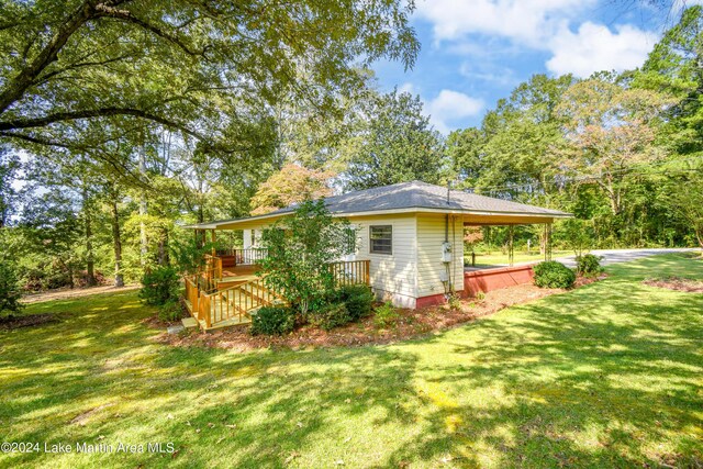 view of side of home with a lawn and a deck