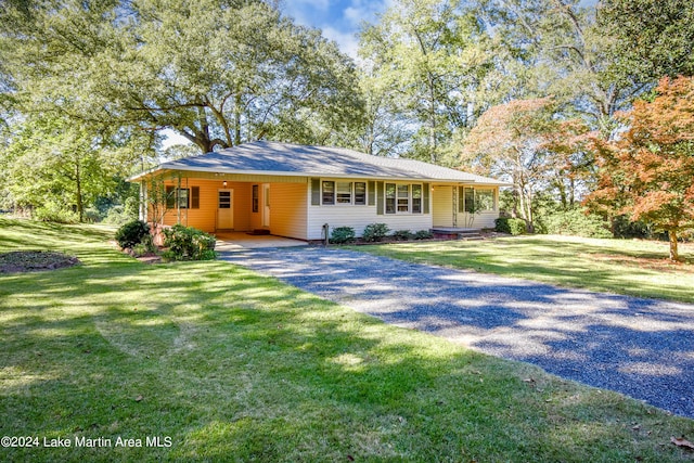 ranch-style house featuring a front lawn and a carport