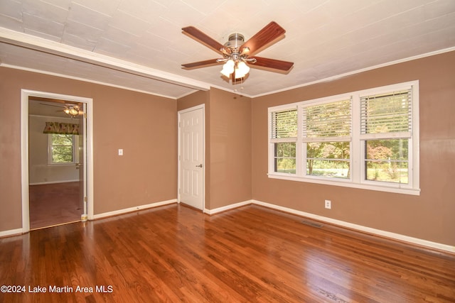 spare room with dark hardwood / wood-style flooring and crown molding