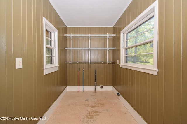 washroom with crown molding and wood walls