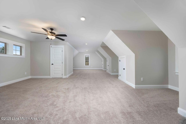 additional living space with ceiling fan, light colored carpet, and vaulted ceiling