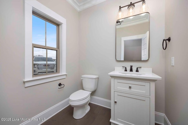 bathroom with hardwood / wood-style flooring, vanity, toilet, and crown molding