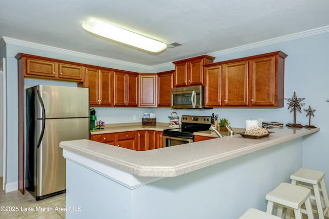 189 Williams Rd Unit # N2, Alexander City, AL 35010 - kitchen with stainless steel appliances, a peninsula, light countertops, a kitchen breakfast bar, and crown molding