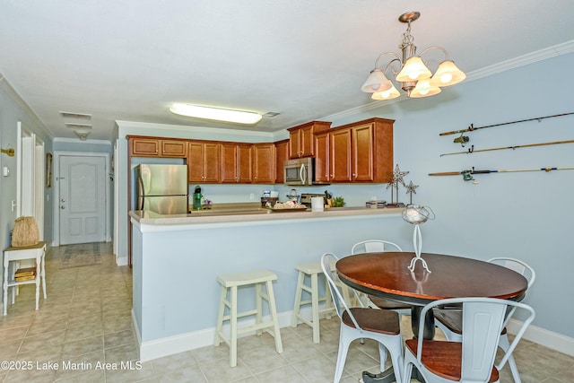 189 Williams Rd Unit # N2, Alexander City, AL 35010 - kitchen with appliances with stainless steel finishes, a peninsula, crown molding, light countertops, and a chandelier