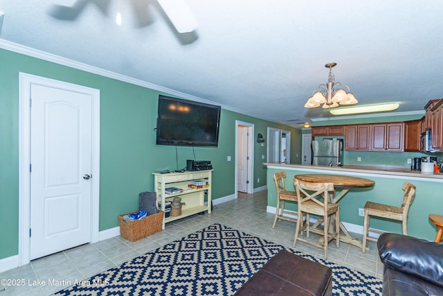 kitchen with crown molding, hanging light fixtures, light tile patterned floors, a notable chandelier, and stainless steel appliances