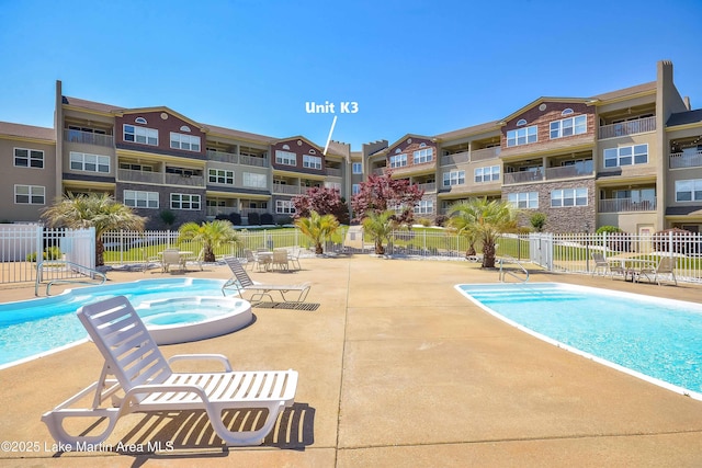 view of swimming pool with a patio area and a community hot tub