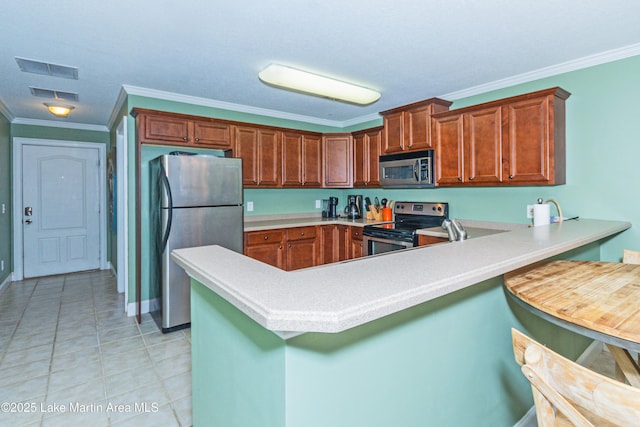 kitchen featuring a kitchen breakfast bar, ornamental molding, kitchen peninsula, and appliances with stainless steel finishes