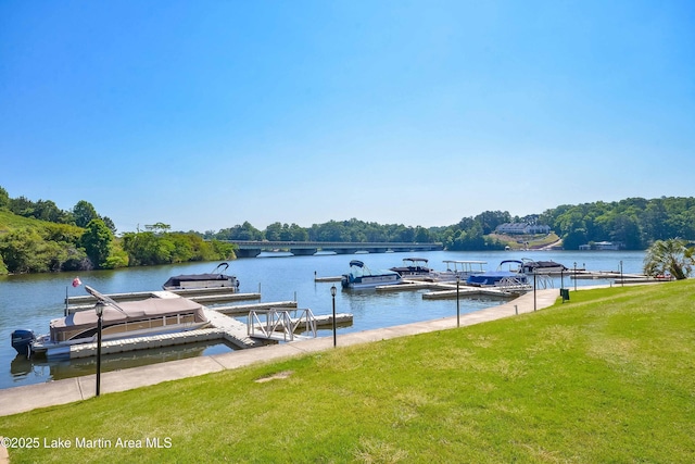 view of dock with a lawn and a water view