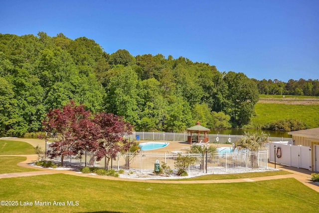 view of home's community with a pool, a yard, a gazebo, and a water view