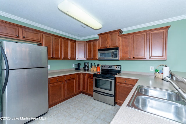 kitchen with sink, ornamental molding, and appliances with stainless steel finishes