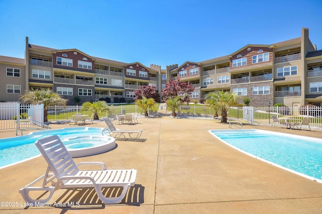 view of pool with a patio and a community hot tub