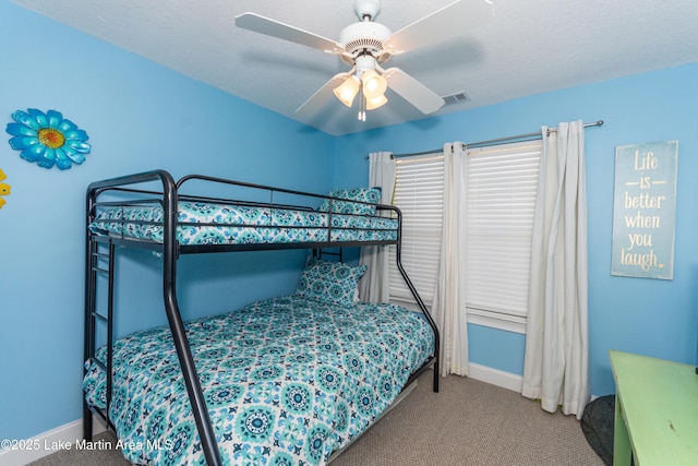 bedroom featuring light carpet, a textured ceiling, and ceiling fan