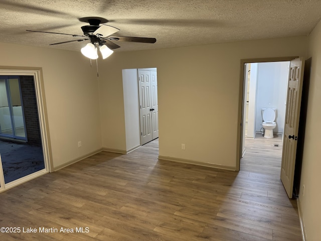 unfurnished room with ceiling fan, light hardwood / wood-style flooring, and a textured ceiling