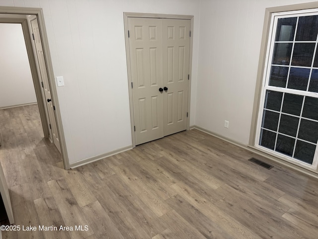 unfurnished bedroom featuring light hardwood / wood-style flooring and a closet