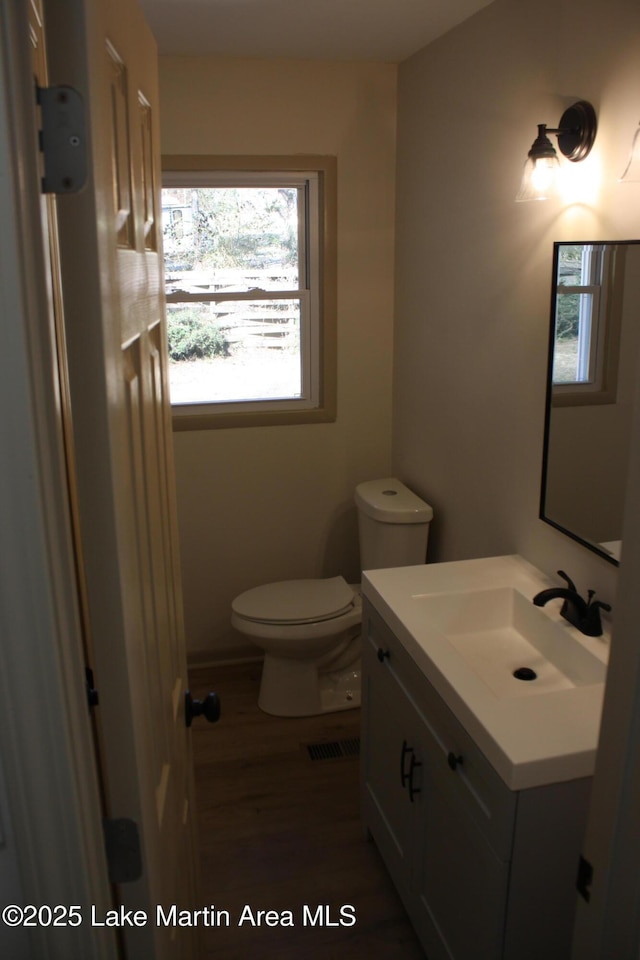 bathroom featuring toilet, visible vents, and vanity