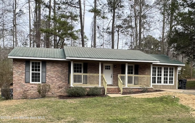 ranch-style home with a porch, a front yard, brick siding, and metal roof