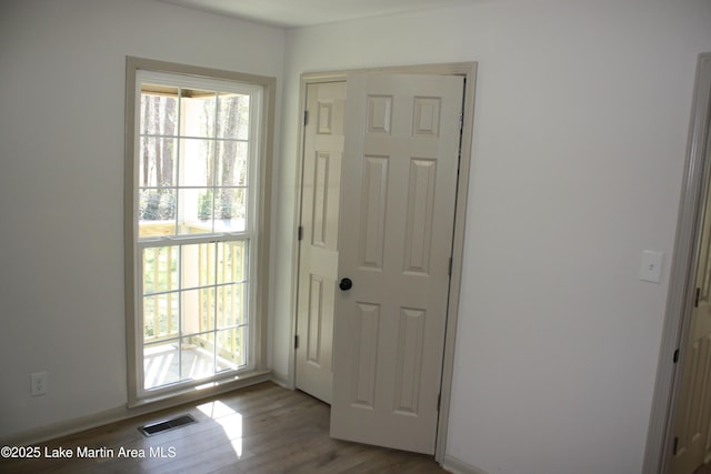 doorway featuring light wood-type flooring and visible vents