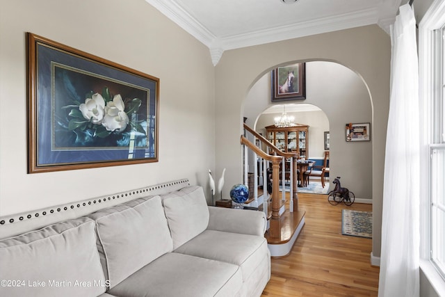 living room featuring wood-type flooring, an inviting chandelier, and ornamental molding