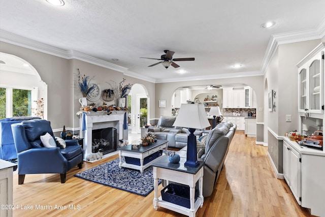 living room with a healthy amount of sunlight, crown molding, and light hardwood / wood-style flooring