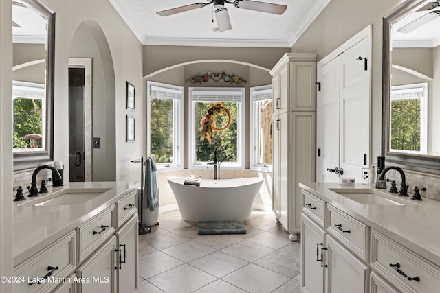 bathroom featuring tile patterned flooring, vanity, tasteful backsplash, and a healthy amount of sunlight