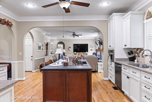 kitchen featuring sink, white cabinets, a textured ceiling, and light wood-type flooring