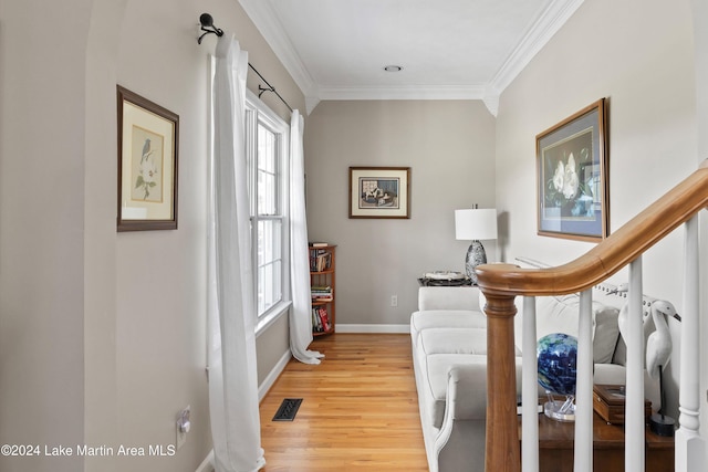 living area with light hardwood / wood-style floors and ornamental molding