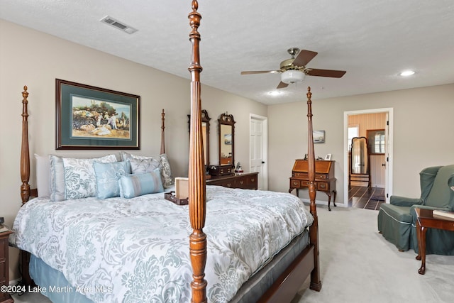 carpeted bedroom with ceiling fan and a textured ceiling