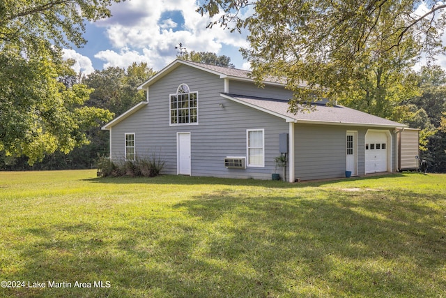 back of house featuring a yard and a garage