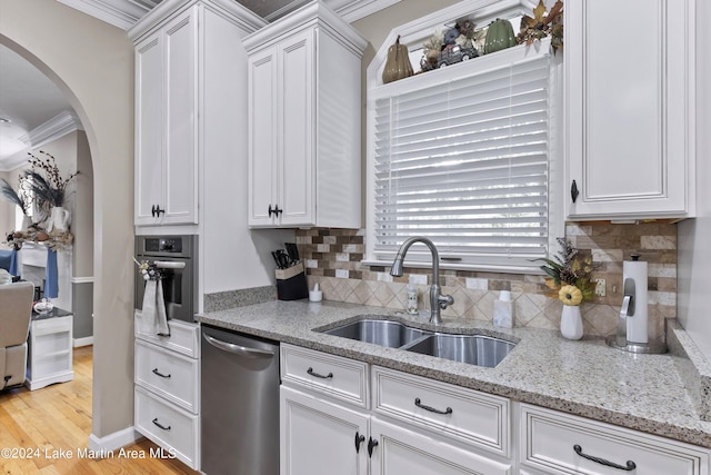 kitchen with decorative backsplash, stainless steel appliances, crown molding, sink, and light hardwood / wood-style floors