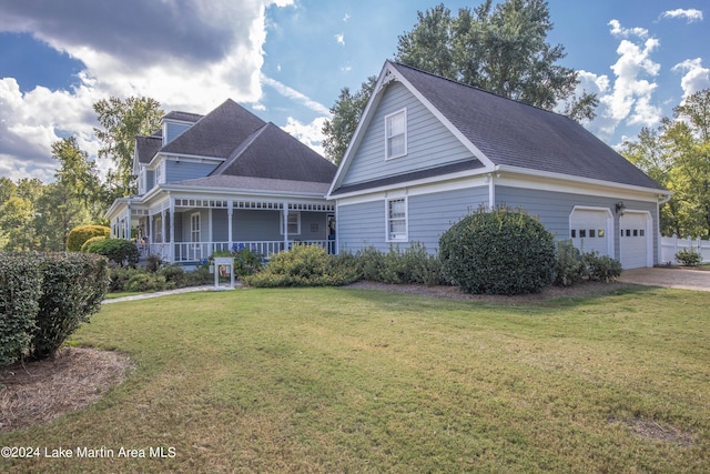 view of front of property featuring a garage, a porch, and a front yard