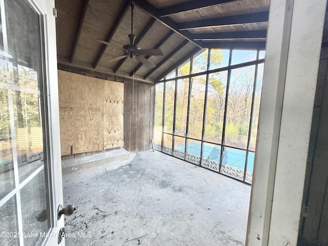 unfurnished sunroom featuring a ceiling fan and vaulted ceiling with beams