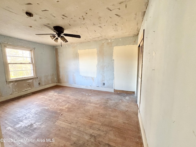 spare room featuring ceiling fan, visible vents, and baseboards