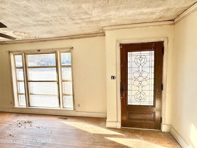 foyer entrance with baseboards, visible vents, wood finished floors, a textured ceiling, and crown molding