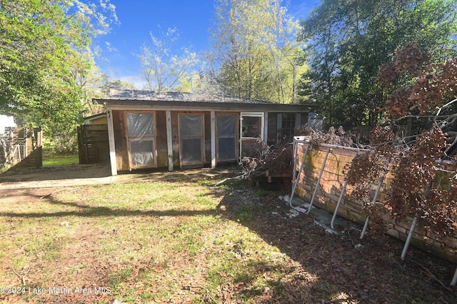 rear view of property featuring a lawn