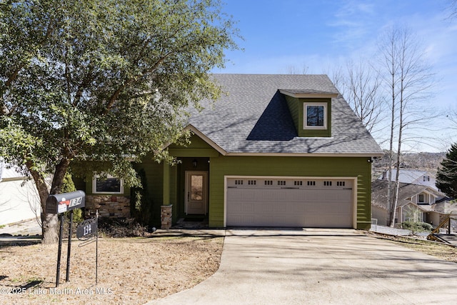 view of front of home with a garage, concrete driveway, a shingled roof, and stone siding