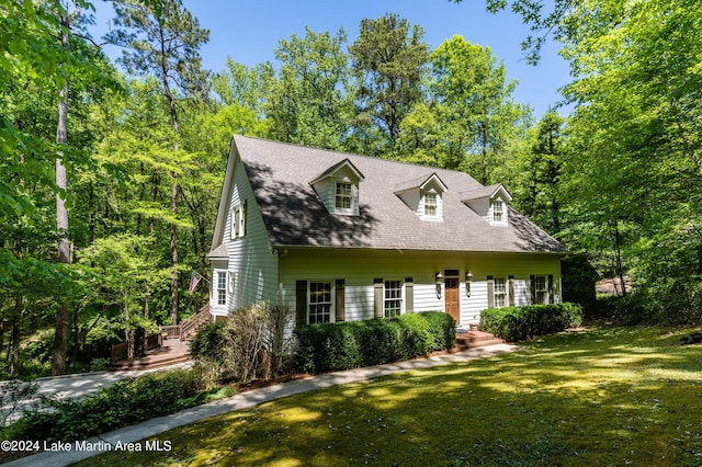 cape cod house featuring a front yard