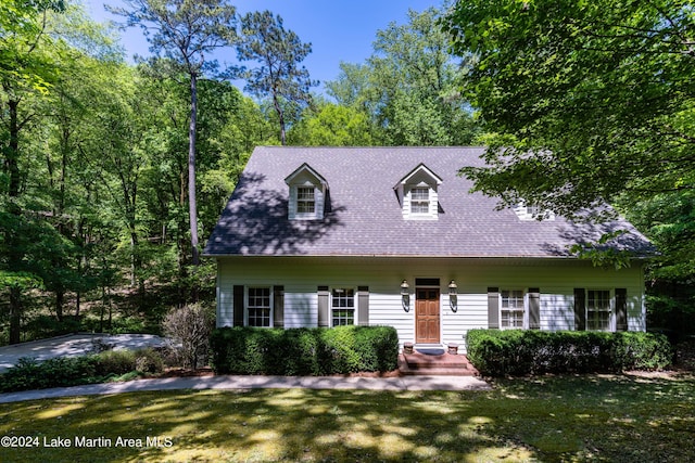 cape cod home featuring a front lawn