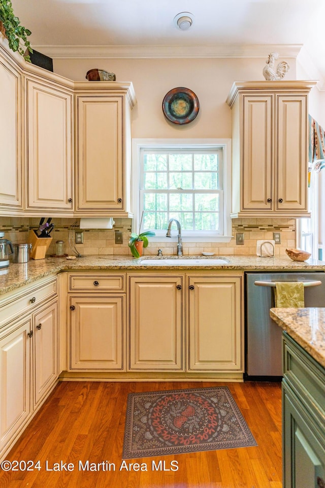 kitchen with crown molding, sink, stainless steel dishwasher, and wood-type flooring