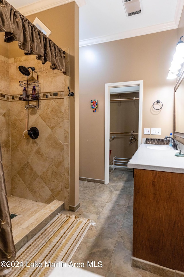 bathroom featuring vanity, tiled shower, and crown molding