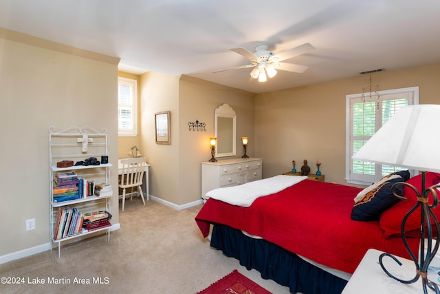 bedroom featuring light carpet, multiple windows, and ceiling fan