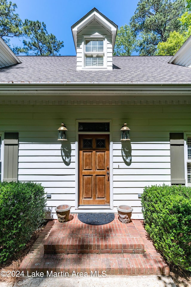 view of exterior entry featuring covered porch