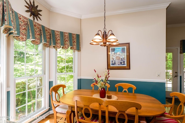 dining area featuring hardwood / wood-style floors, plenty of natural light, ornamental molding, and a chandelier