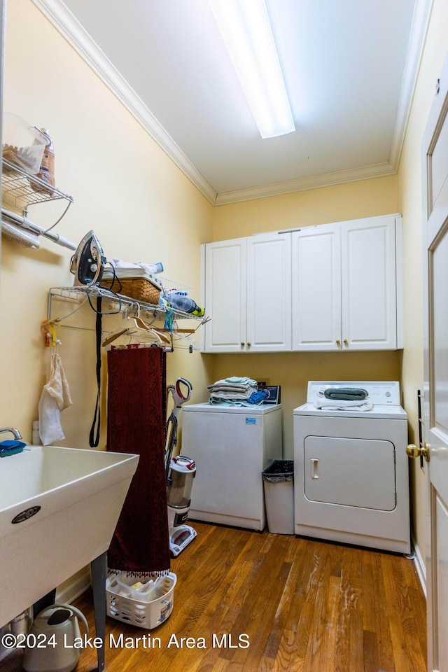 laundry area with independent washer and dryer, cabinets, dark hardwood / wood-style floors, and ornamental molding