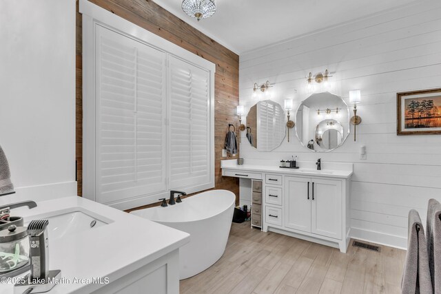 116 Glynmere Park, Alexander City, AL 35010 - bathroom featuring wooden walls, a soaking tub, two vanities, and wood finished floors