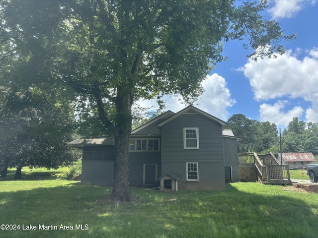 rear view of property with a yard and a wooden deck