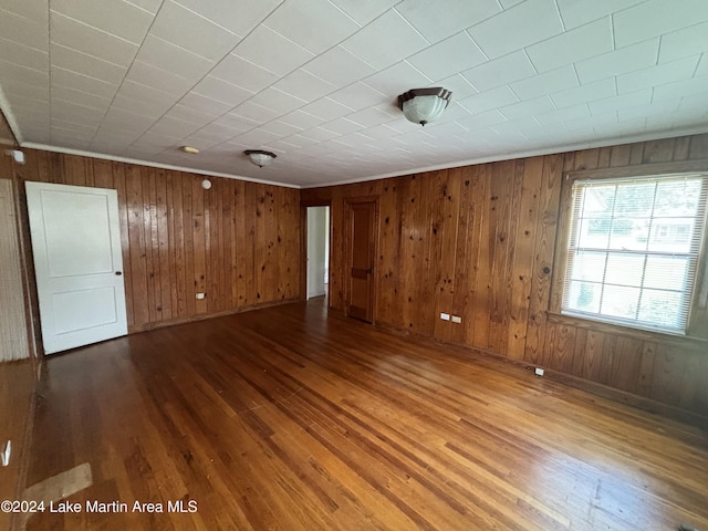 spare room with hardwood / wood-style floors and wood walls