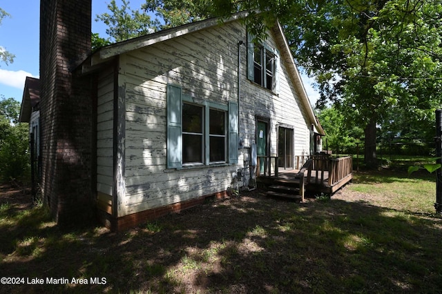 view of home's exterior with a lawn and a wooden deck